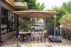 a patio with tables and chairs under an umbrella at Onyx Hotel Bishkek in Bishkek