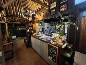 a man standing behind a bar in a restaurant at Secret Garden Surf Resort, walk to waves in Pulau Gilkaliantan
