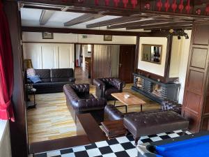 a living room with leather furniture and a fireplace at Ferienhaus Lemmerheide in Rüthen