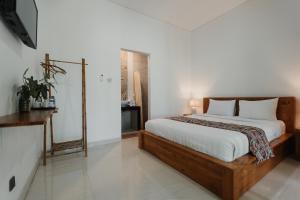 a bedroom with a bed and a television in it at Dana's Kelating Guest House, Close to Kelating Beach in Tabanan