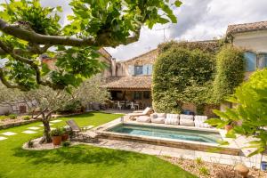 a garden with a swimming pool and a house at Le Jardin Secret in Grignan