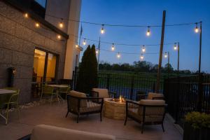 a patio with a fire pit and chairs and lights at Hampton Inn Summersville in Summersville