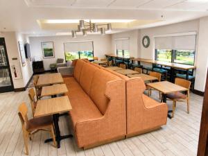 a restaurant with a couch and tables and chairs at Hampton Inn Summersville in Summersville