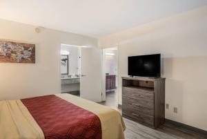a hotel room with a bed and a flat screen tv at Econo Lodge Thomasville in Thomasville