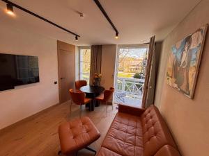 a living room with a couch and a table and chairs at Marių vilos apartamentai Balcony with a Lagoon View in Juodkrantė