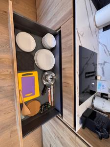 a drawer in a cabinet with plates and other items at Marių vilos apartamentai Balcony with a Lagoon View in Juodkrantė +19 photos