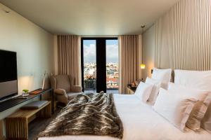 a hotel room with a large bed and a window at Memmo Príncipe Real - Design Hotels in Lisbon