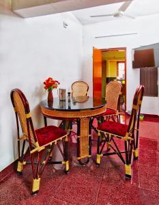 Rams Guest House Near Sree Chithra and RCC في تريفاندروم: طاولة طعام مع كراسي وطاولة وطاولة