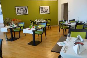 uma sala de jantar com mesas e cadeiras e paredes verdes em Residenz Senevita Westside em Berna