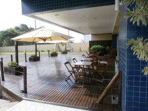 a deck with tables and chairs and an umbrella at Icaropê Hotel in Concordia