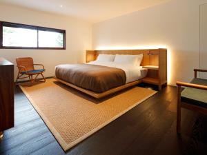 a bedroom with a bed and a chair at 翠門亭 in Nara