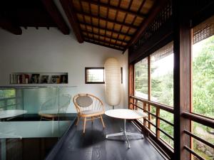 a room with a table and chairs and windows at 翠門亭 in Nara