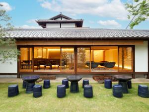 a house with glass doors and stools in a yard at 翠門亭 in Nara