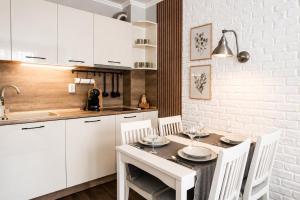 a kitchen with white cabinets and a table and chairs at Cozy & Elegant Stay in Veliko Tŭrnovo