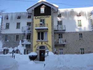 Un bâtiment avec un panneau dans la neige dans l'établissement Albergo Capriolo, à Sestola