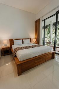 a bedroom with a large bed and a large window at Dana's Kelating Guest House, Close to Kelating Beach in Tabanan +14 photos