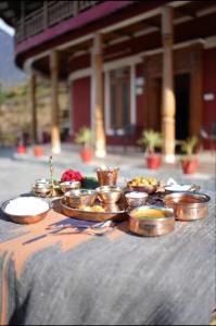 a table with bowls and plates of food on it at Jhumelo Homestay, Ukhimath in Ukhimath