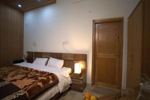 a bedroom with a large bed and a wooden door at Jhumelo Homestay, Ukhimath in Ukhimath