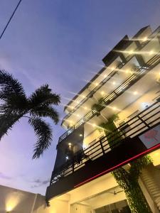 a building with a palm tree in front of it at City Hotel Thalawathugoda in Talawatugoda