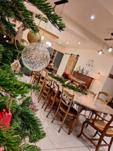 a christmas tree in a dining room with a table and chairs at Chez Mémère in Rolleville