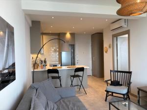 a living room and kitchen with a couch and chairs at Panoramic Sea View in Budva