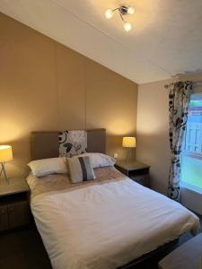 a bedroom with a large bed with two lamps at Southerness Holiday Home Cheri Sleeps 4 Mon-Fri Fri-Mon with Solway Holiday Homes in Mainsriddle