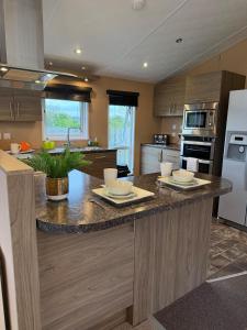 a kitchen with a large island with two plates on it at Southerness Holiday Home Cheri Sleeps 4 Mon-Fri Fri-Mon with Solway Holiday Homes in Mainsriddle