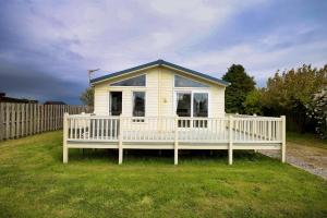 a small white house with a large porch at Southerness Holiday Home Cheri Sleeps 4 Mon-Fri Fri-Mon with Solway Holiday Homes in Mainsriddle
