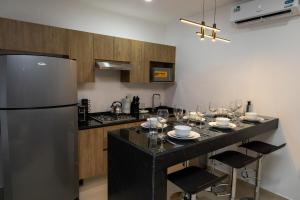 a kitchen with a refrigerator and a table with wine glasses at Sky Luxury Residence, 12th Floor, Panoramic in Guadalajara