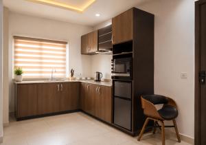 a kitchen with a black refrigerator and a chair in it at The Savannah Hotel, Garki in Abuja
