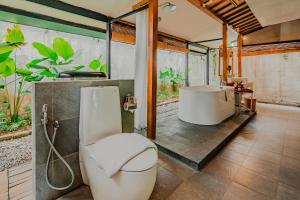 ein Badezimmer mit Badewanne, Toilette und Waschbecken in der Unterkunft Ayom Java Village Solo in Solo + 42 Fotos
