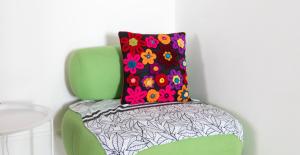 a green chair with a colorful flower pillow on it at La Casa di Dadà in Avezzano