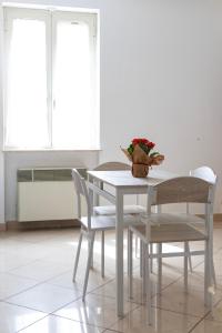 a white table and chairs with a vase of flowers on it at La Casa di Dadà in Avezzano +14 photos