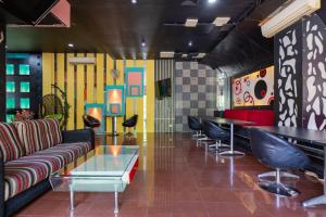 a lobby with a couch and tables and colorful walls at Sans Hotel International Surabaya in Gubeng