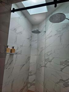 a bathroom with a shower with white marble tiles at Hill Top Park - Apple Tree Studio in Kilmore