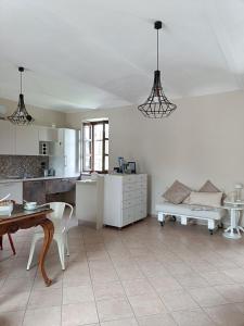 a kitchen and living room with a table and a couch at La Casa del Merlo in Rodello