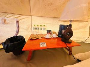 a table in a tent with a lamp on it at DaLart Glamping & Coffee in Ấp Ða Lôc