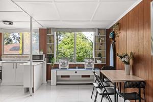 a kitchen and dining room with a table and chairs at Simple 2-Double Bed Studio Stay at Peakhurst in Peakhurst