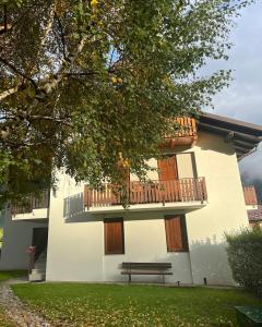 a building with a balcony and a bench at Dimaro Apartment in Monclassico