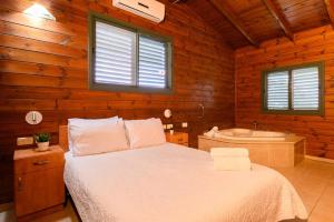a bedroom with a bed and a bath tub at בינות התמרים- 3 צימרים מהממים עם בריכה וג'קוזי ספא! in Menaẖemya +15 photos