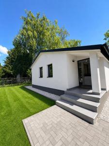 a white house with a staircase in a yard at Peaceful Garden Hideaway in Gárdony