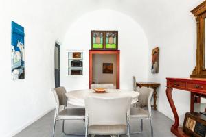 a dining room with a white table and chairs at Timedrops Santorini Villas-Private pool in Emporio