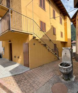 a yellow building with a staircase on the side of it at Alloggio valle stura in Vinadio