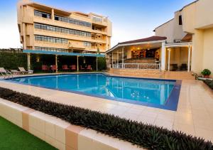 a swimming pool in front of a building at The Savannah Hotel, Garki in Abuja
