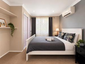 a bedroom with a large bed with two pillows at Blue Mountains charm with Spa! in Wentworth Falls