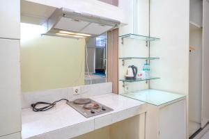 a kitchen with a counter top with a stove at Sans Hotel International Surabaya in Gubeng +32 photos
