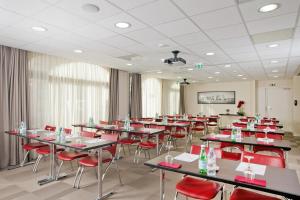 a dining room with tables and red chairs at Residhome Arcachon Plazza in Arcachon