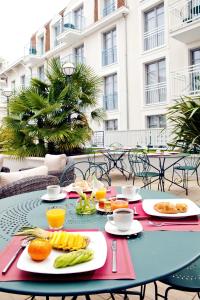 - une table avec des assiettes de nourriture sur la terrasse dans l'établissement Residhome Arcachon Plazza, à Arcachon