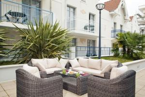 a patio with two wicker chairs and a table at Residhome Arcachon Plazza in Arcachon