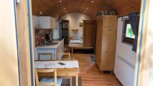 a small kitchen with a table in a tiny house at Pfälzer Zirkuswagen in Ranschbach +4 photos